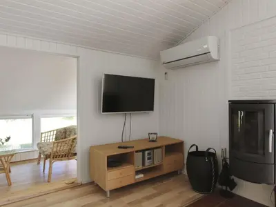 a living room with a flat screen tv on the wall at Holiday Home Eden - 800m from the sea by Interhome in Løkken