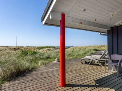 a red pole on a porch of a beach house at Holiday Home Lauri - 350m from the sea by Interhome in Løkken