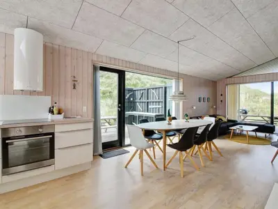 a kitchen and dining room with a table and chairs at Holiday Home Mikkel - 300m from the sea by Interhome in Løkken