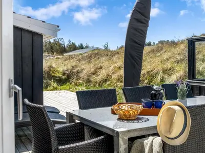 a patio with a table and chairs on a deck at Holiday Home Ingela - 350m from the sea by Interhome in Løkken