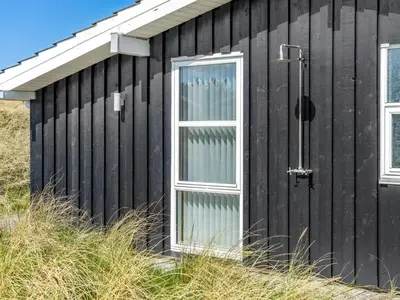 a black house with a window on the side of it at Holiday Home Ingela - 350m from the sea by Interhome in Løkken