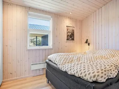 a bedroom with a bed and a window at Holiday Home Ingela - 350m from the sea by Interhome in Løkken