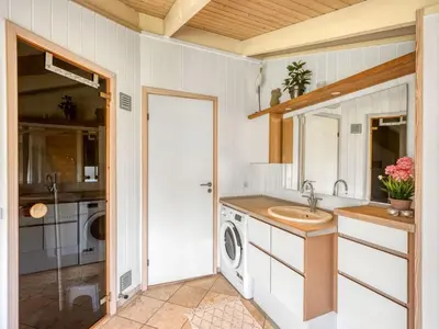 a bathroom with a sink and a washing machine at Holiday Home Asol - 650m from the sea by Interhome in Løkken
