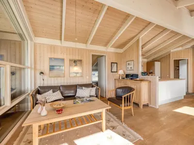 a living room with a couch and a table at Holiday Home Asol - 650m from the sea by Interhome in Løkken