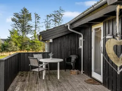 a patio with a table and chairs on a deck at Holiday Home Asol - 650m from the sea by Interhome in Løkken