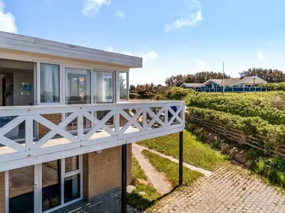 a view of a house with a balcony and a vineyard at Holiday Home Mielikki - 200m from the sea by Interhome in Løkken