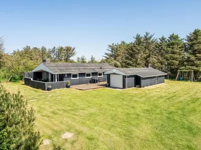 a large yard with a house with a playground at Holiday Home Tonja - 300m from the sea by Interhome in Løkken