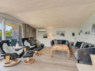 a living room with couches and chairs and a table at Holiday Home Tonja - 300m from the sea by Interhome in Løkken