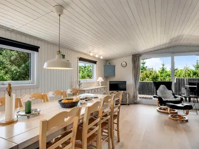 a kitchen and dining room with a table and chairs at Holiday Home Tonja - 300m from the sea by Interhome in Løkken