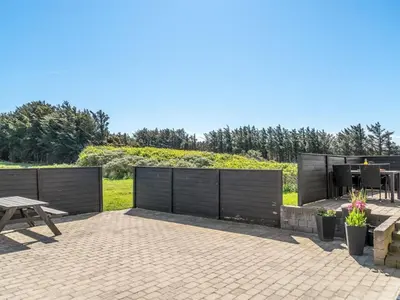 a patio with a wooden fence and a picnic table at Holiday Home Nayeli - 275m from the sea by Interhome in Løkken