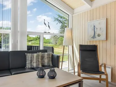 a living room with a black couch and a table at Holiday Home Elvan - 450m from the sea by Interhome in Løkken