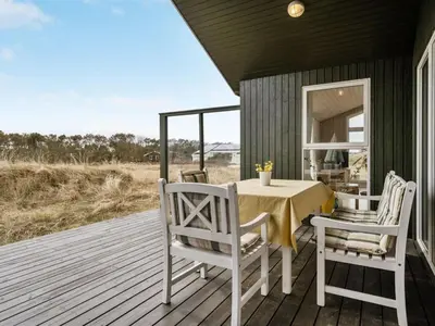 a porch with a table and chairs on a deck at Holiday Home Elco - 450m from the sea by Interhome in Løkken