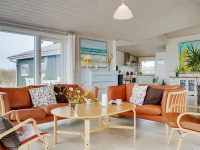 a living room with a couch and a table at Holiday Home Elco - 450m from the sea by Interhome in Løkken