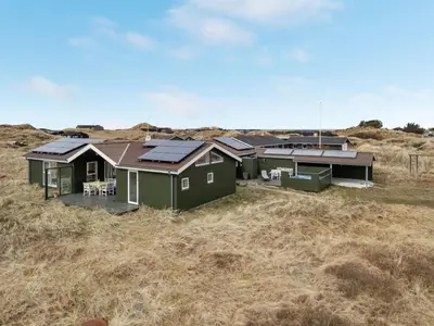 a green house with solar panels on it in a field at Holiday Home Elco - 450m from the sea by Interhome in Løkken