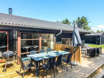 a patio with a table and chairs on a deck at Holiday Home Paulette - 450m from the sea by Interhome in Løkken