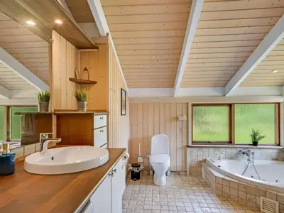 a bathroom with two sinks and a tub and a toilet at Holiday Home Paulette - 450m from the sea by Interhome in Løkken