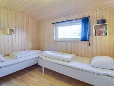 two beds in a room with a window at Holiday Home Susan - 600m from the sea by Interhome in Løkken