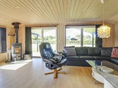 a living room with a leather chair and a couch at Holiday Home Susan - 600m from the sea by Interhome in Løkken