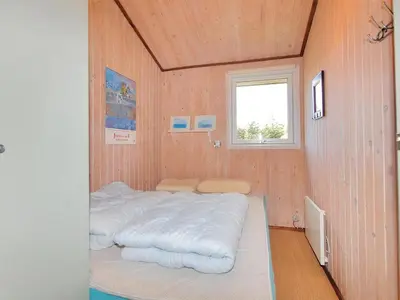 a room with a bed in a room with a window at Holiday Home Taina - 1-1km from the sea by Interhome in Løkken