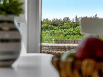 a basket of fruit sitting on a table next to a window at Holiday Home Klakke - 900m from the sea by Interhome in Løkken