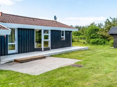 a small blue house with a large backyard at Holiday Home Klakke - 900m from the sea by Interhome in Løkken