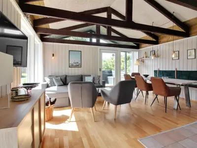 a living room with a couch and a table and chairs at Holiday Home Eyer - 800m from the sea by Interhome in Løkken
