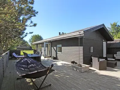 a small house with a boat on a deck at Holiday Home Eyer - 800m from the sea by Interhome in Løkken