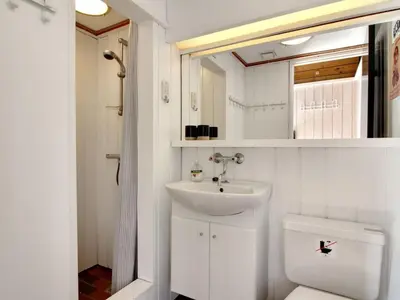 a white bathroom with a sink and a toilet at Holiday Home Eyer - 800m from the sea by Interhome in Løkken