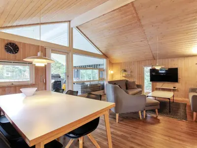 a dining room and living room with a table and chairs at Holiday Home Elsemaria - 1-3km from the sea by Interhome in Løkken