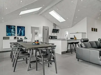 a kitchen and living room with a table and chairs at Holiday Home Fegge - 1-5km from the sea by Interhome in Løkken