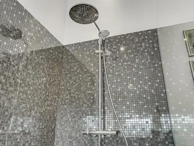 a shower with a shower head in a bathroom at Holiday Home Fegge - 1-5km from the sea by Interhome in Løkken