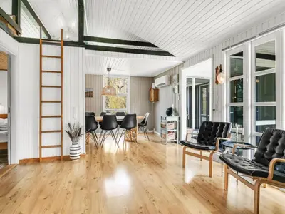 a living room with black chairs and a table at Holiday Home Lempi - 300m from the sea by Interhome in Løkken