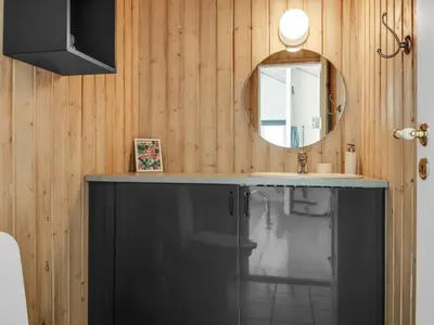 a bathroom with a sink and a mirror at Holiday Home Lempi - 300m from the sea by Interhome in Løkken
