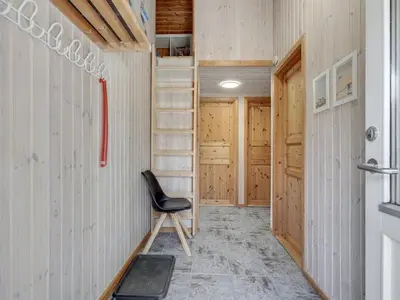 a chair in a hallway with wooden walls at Holiday Home Sonke - 500m from the sea by Interhome in Løkken