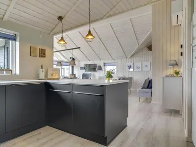 a kitchen with a black island in a room at Holiday Home Ina - 1-2km from the sea by Interhome in Løkken