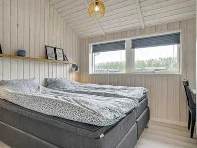 a bedroom with a bed in a room with a window at Holiday Home Ina - 1-2km from the sea by Interhome in Løkken