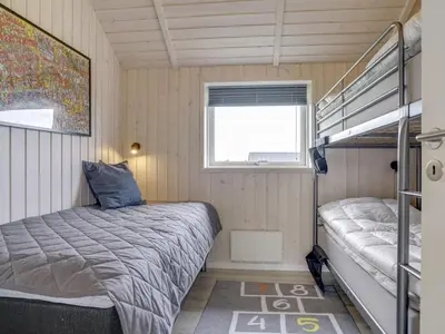 a bedroom with a bed and a bunk bed at Holiday Home Ina - 1-2km from the sea by Interhome in Løkken