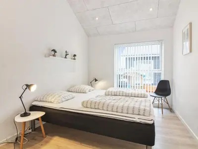 a bedroom with a large bed and a window at Holiday Home Edgar - 1-5km from the sea by Interhome in Løkken