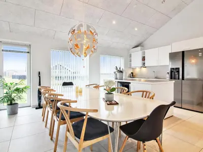 a kitchen and dining room with a table and chairs at Holiday Home Edgar - 1-5km from the sea by Interhome in Løkken