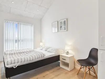 a bedroom with a bed and a desk and a chair at Holiday Home Edgar - 1-5km from the sea by Interhome in Løkken