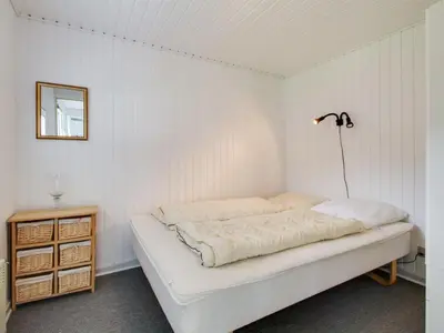 a white bedroom with a bed and a lamp at Holiday Home Gitten - 600m from the sea by Interhome in Løkken