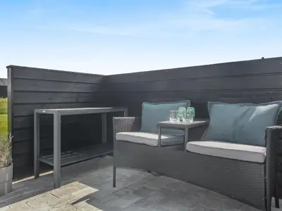 a patio with two chairs and a table at Holiday Home Dwerg - 1-5km from the sea by Interhome in Løkken