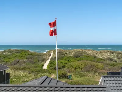 a canadian flag on a flag pole on the beach at Holiday Home Ecaterina - 100m from the sea by Interhome in Løkken