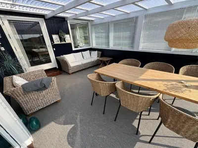 a conservatory with a table and chairs and a couch at Holiday Home Ecaterina - 100m from the sea by Interhome in Løkken