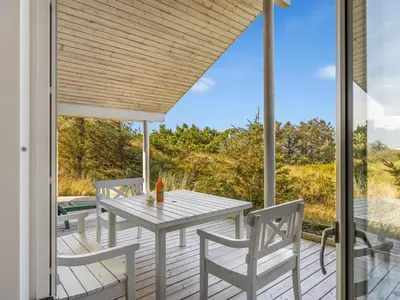 a patio with a table and chairs on a deck at Holiday Home Elna - 400m from the sea by Interhome in Løkken