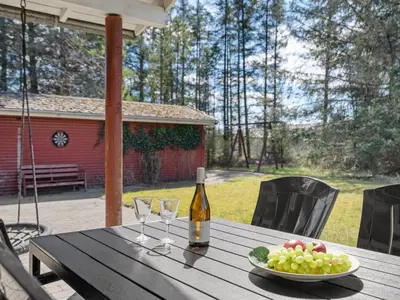a table with a plate of grapes and a bottle of wine at Holiday Home Herwarth - 3-3km from the sea by Interhome in Blokhus