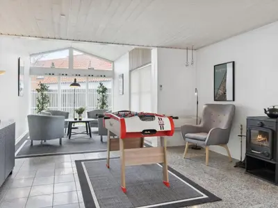 a living room with a table and a stove at Holiday Home Frethi - 350m from the sea by Interhome in Blokhus
