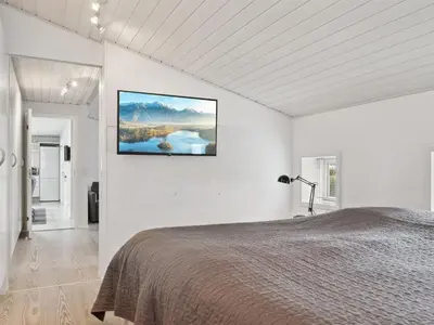 a bedroom with a large bed in a white wall at Holiday Home Frethi - 350m from the sea by Interhome in Blokhus