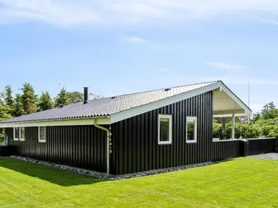 a black house with a pitched roof at Holiday Home Marli - 700m from the sea by Interhome in Blokhus