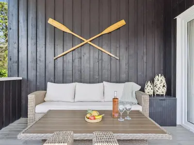 a large clock on a wall above a table with wine glasses at Holiday Home Marli - 700m from the sea by Interhome in Blokhus